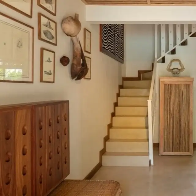 In the living room, modern comforts stay discreet -the TV and fridge hidden in wood so nothing…