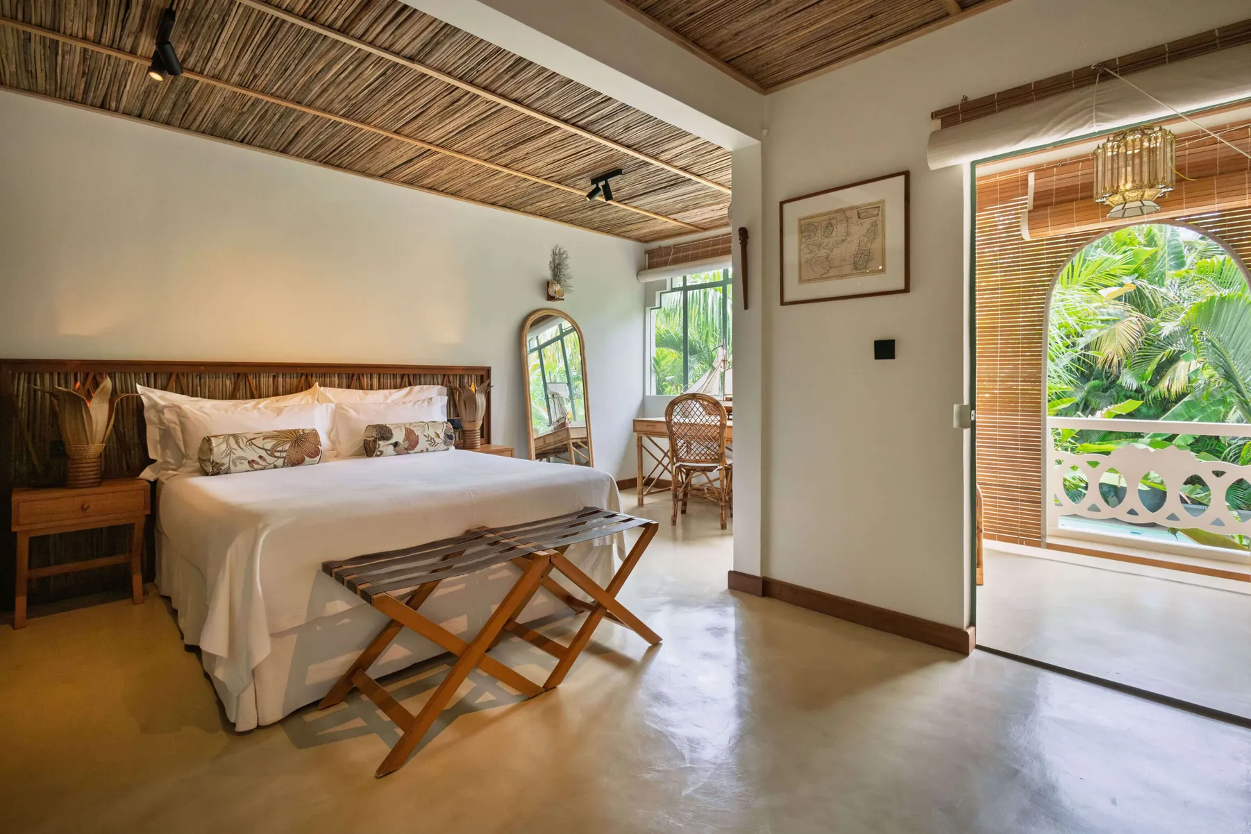Deluxe Family Suite bedroom with a king-size bed, opening onto a balcony over the garden