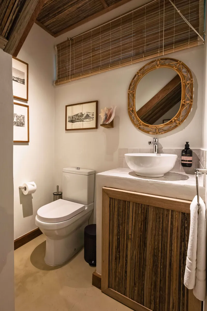 Guest toilet with a washbasin and a rattan-framed mirror