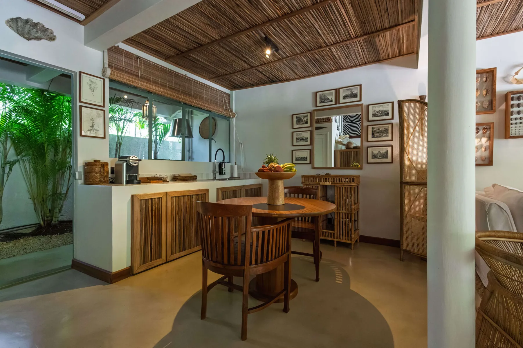 Round dining table and kitchen counter with coffee machine, by a garden window