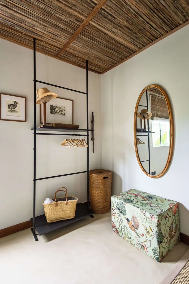Dressing area with an open clothes rail, oval mirror and laundry basket
